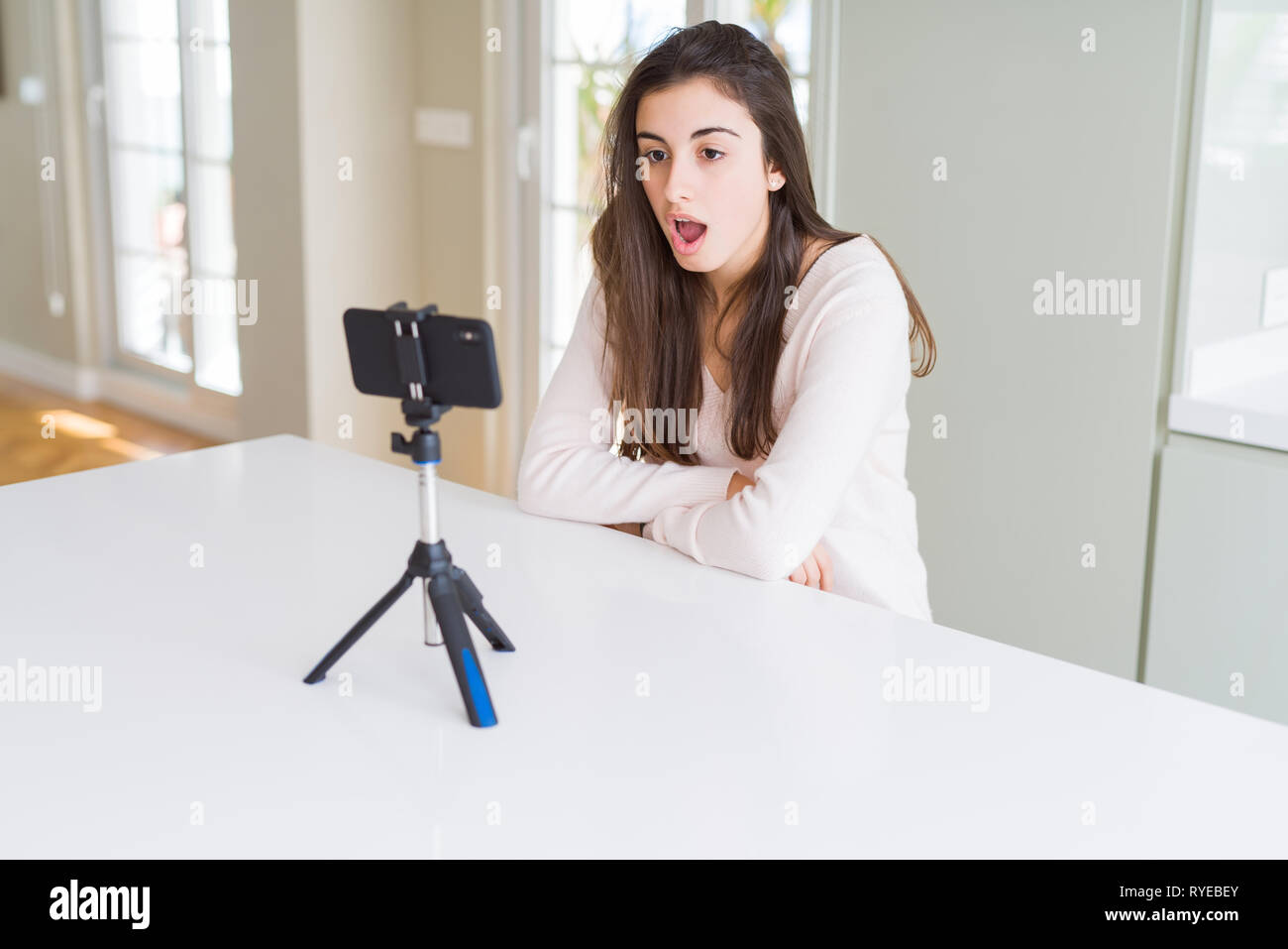Beautiful young woman recording selfie video with smartphone webcam scared  in shock with a surprise face, afraid and excited with fear expression  Stock Photo - Alamy