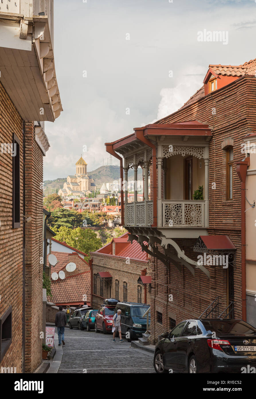 TBILISI, GEORGIA - SEPTEMBER 23, 2018: Scenic view of old city Tbilisi, narrow steep street coming down from hill overlooking the Cathedral of Holy Tr Stock Photo