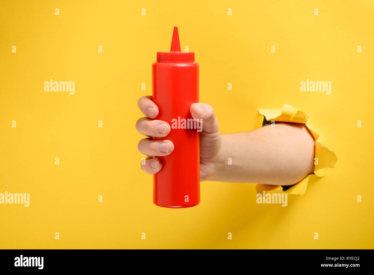 Hand taking a ketchup bottle Stock Photo Alamy