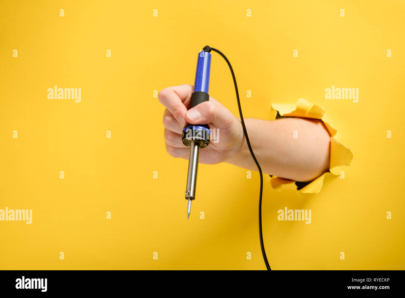 Hand holding a soldering iron Stock Photo