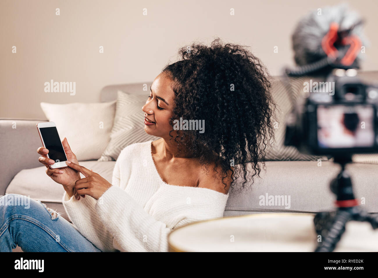 Female vlogger using smartphone while recording a video Stock Photo