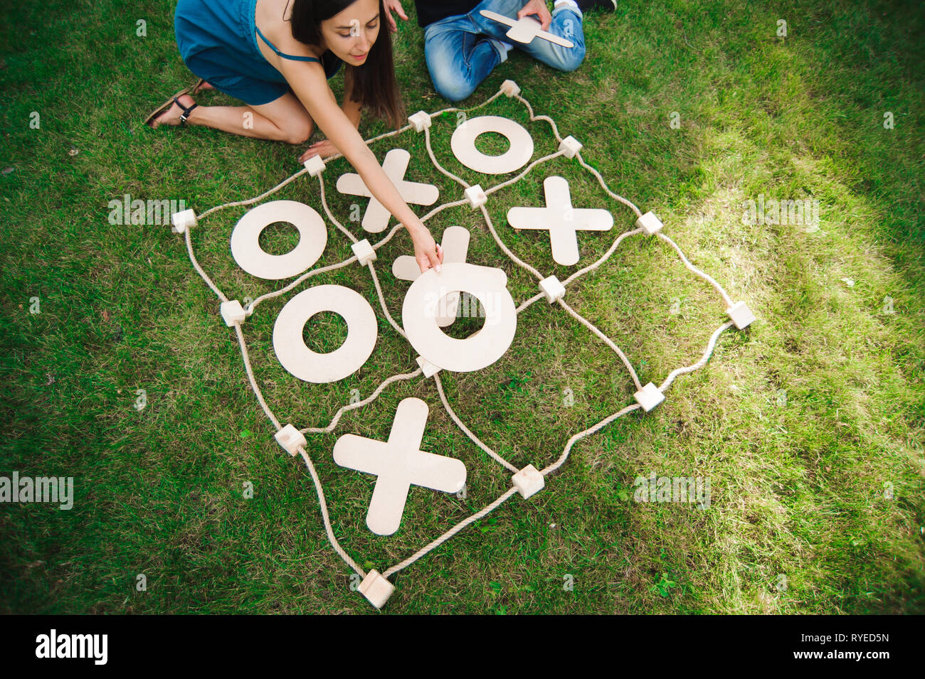 Friends playing tic-tac-toe on green grass. Big Tic Tac Toe game. Guy and  girl playing outdoors Stock Photo - Alamy