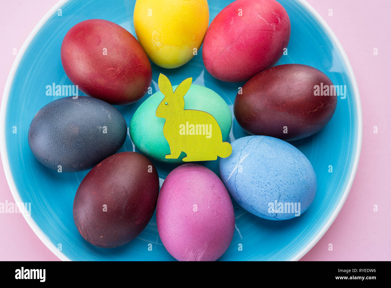 Colorful Easter eggs as an attribute of Easter celebration. Pink background. Stock Photo