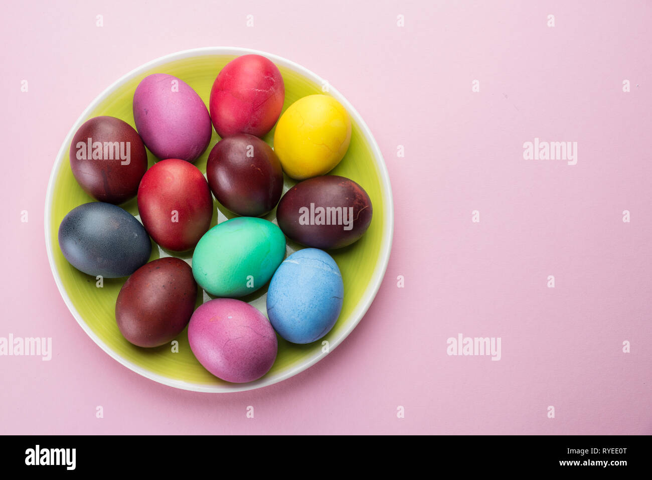 Colorful Easter eggs as an attribute of Easter celebration. Pink background. Stock Photo