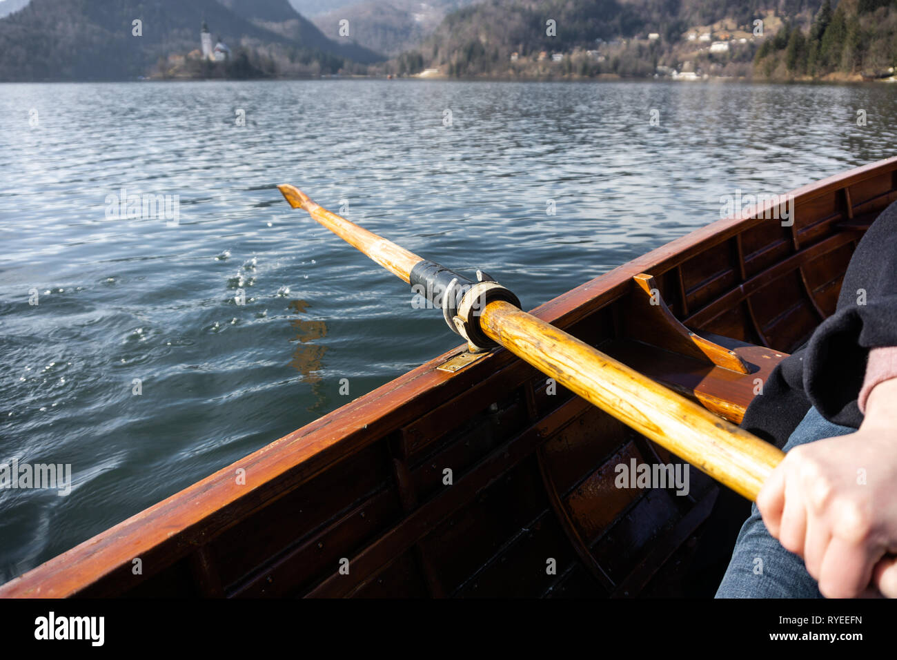 Young woman using paddle on a wooden boat Lake Bled Slovenia rowing on wooden boats Stock
