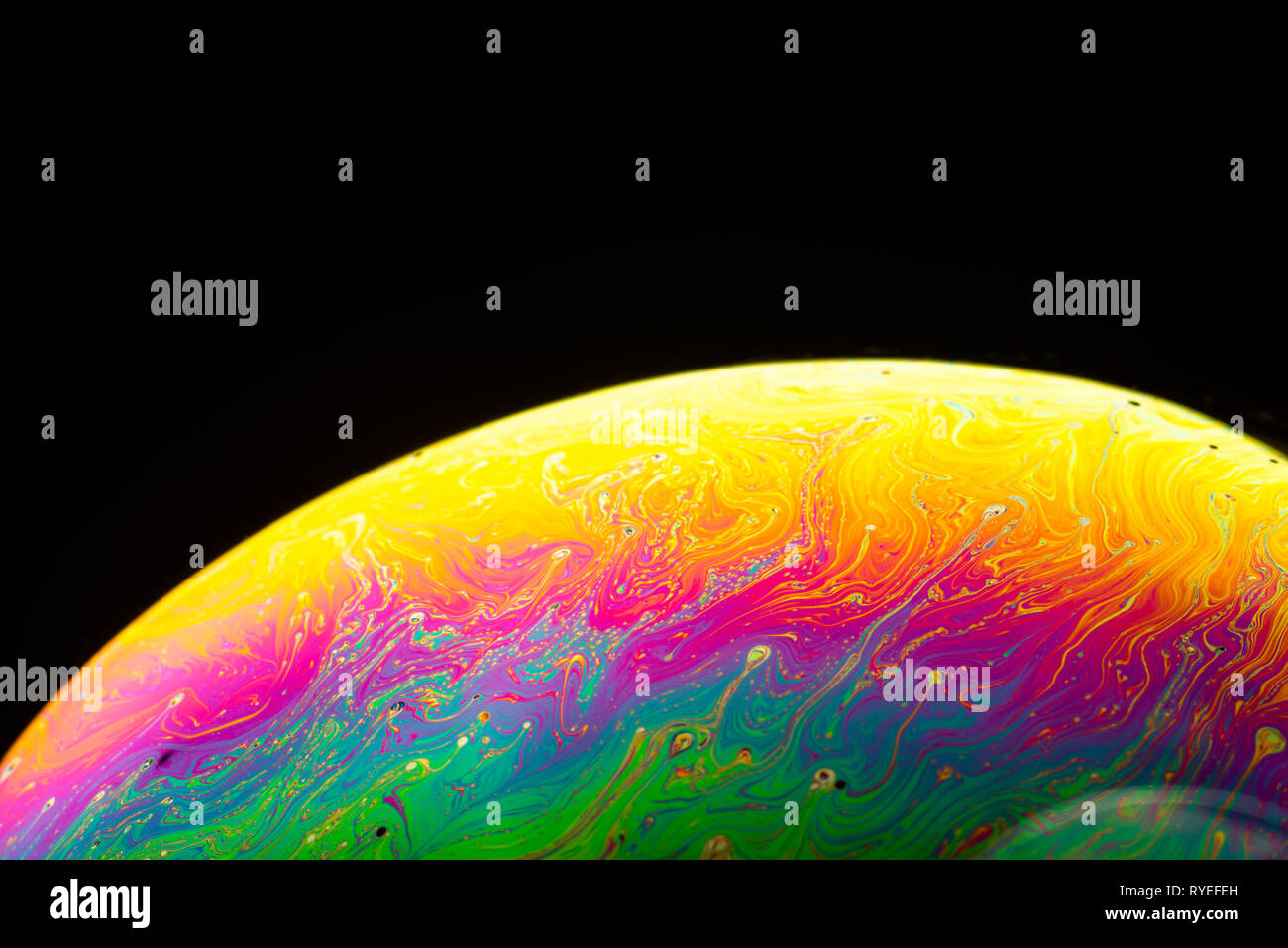 Abstract background made from soap bubble reflecting light. Rainbow soap bubble on a dark background. Stock Photo