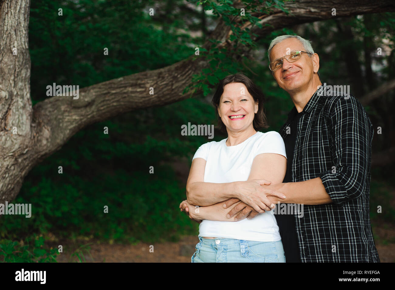 Romantic senior couple walk through the woods Stock Photo - Alamy