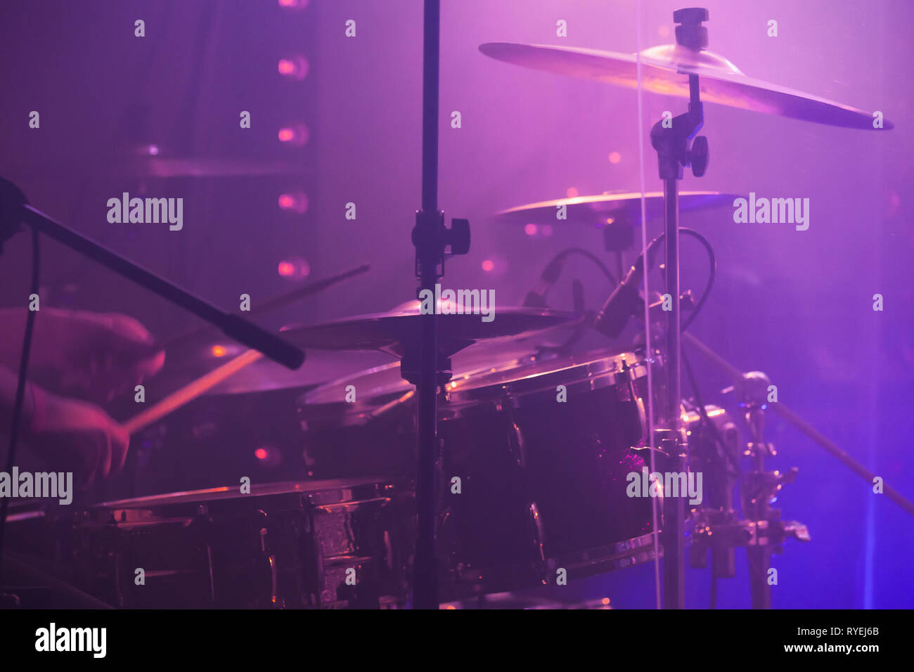 Live music photo background, rock drum set with cymbals in purple stage lights. Closeup photo, soft selective focus Stock Photo