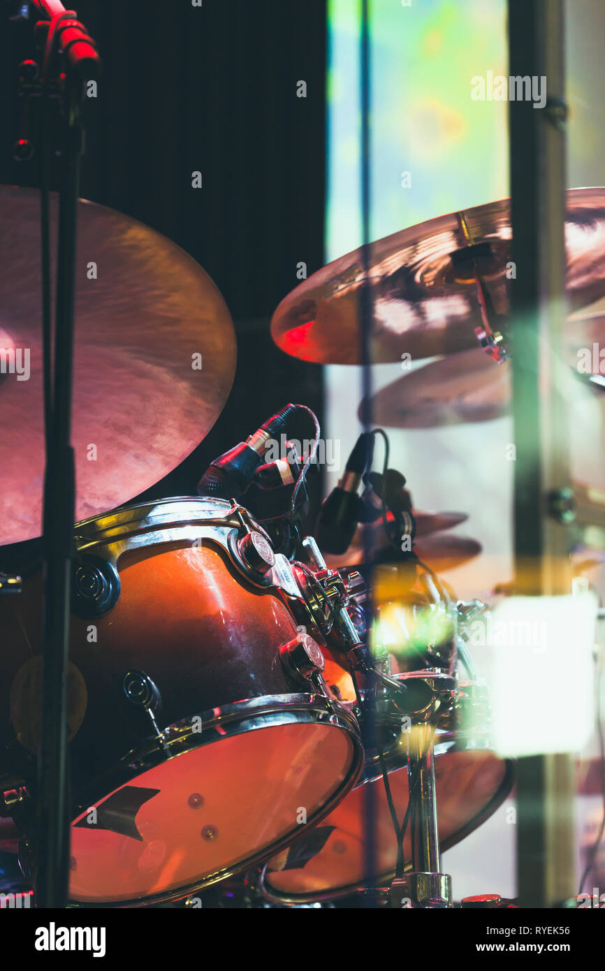Drum set on a stage with colorful illumination, life rock music vertical photo background Stock Photo