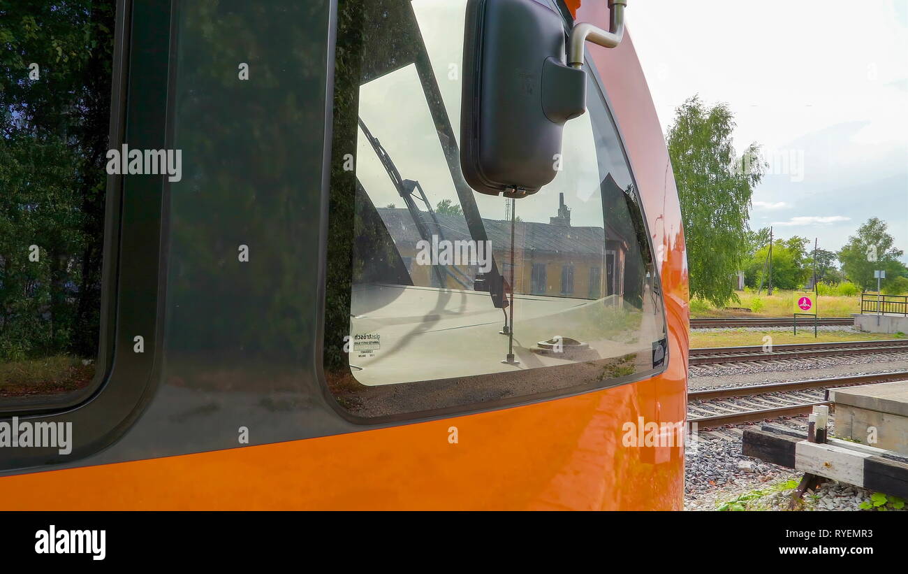 The side mirror of the big orange train in the station with the glass mirror on the front Stock