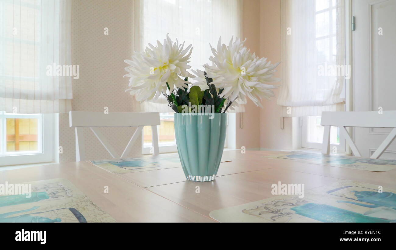 The Round Table In The Dining Area With The Flower Vase On The Top