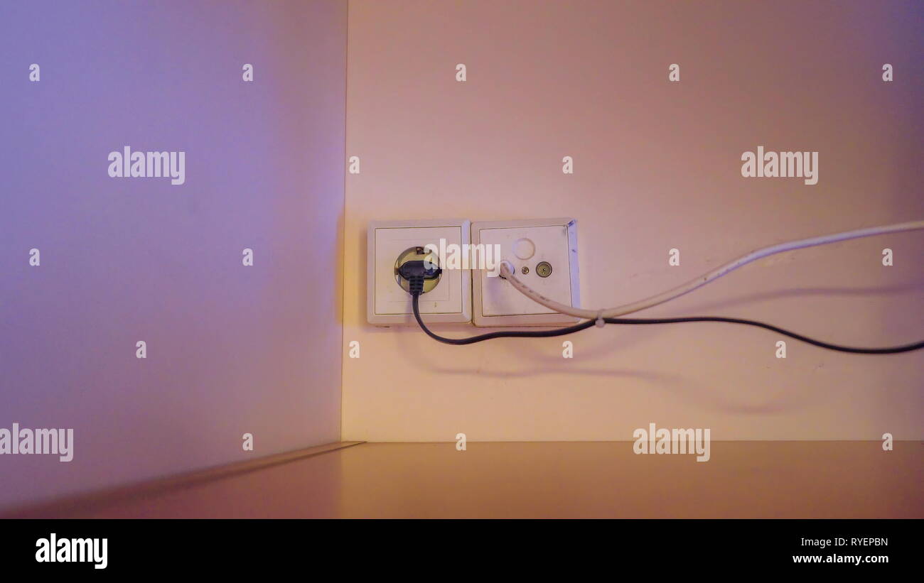 Closer look of the sockets and wires on the wall inside the bedroom