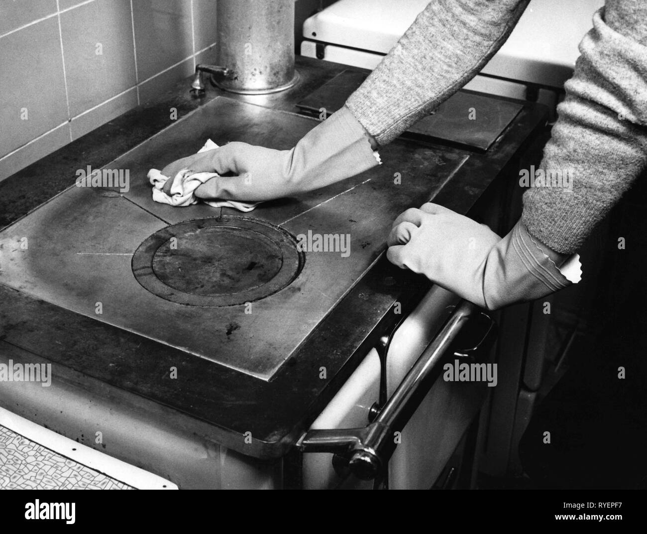 household, kitchen and kitchenware, cleaning a coal range, 1960s, range, stoves, hob, stove, stove top, stovetop, cook, cooking, cleanliness, cleanse, cleansing, cloth, cloths, rubber glove, rubber gloves, glove, gloves, household chores, do the chores, housekeep, domestic work, housework, cooker, cookers, household, households, kitchen, kitchens, cleaning, clean, historic, historical, people, 20th century, Additional-Rights-Clearance-Info-Not-Available Stock Photo