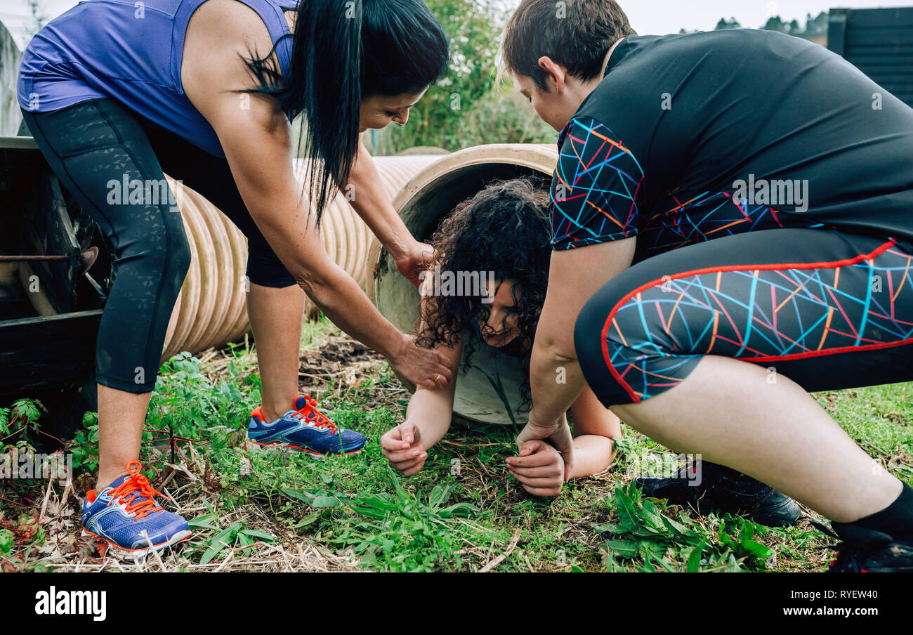 Participants obstacle course going through a pipe Stock Photo