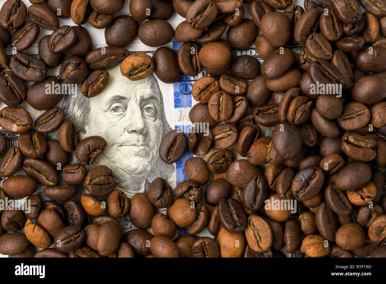 Coffee beans and one hundred dollar bill. Roasted coffee beans