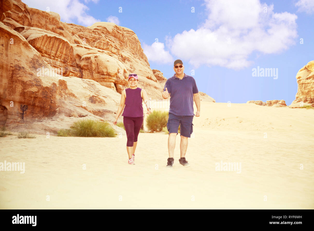 Multi ethnic couple walking happily after an adventure in the desert of Wadi Rum. Stock Photo