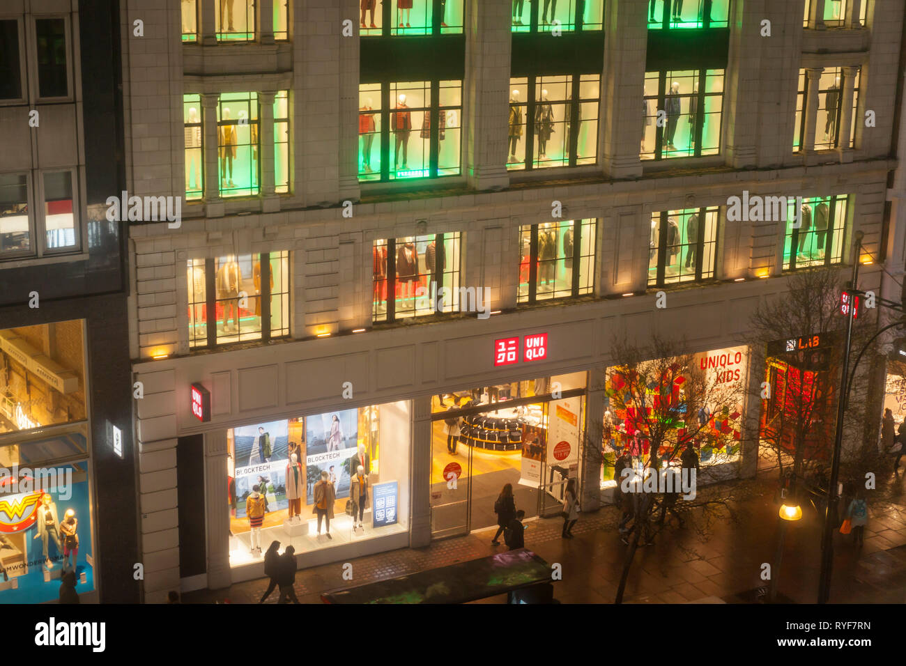 The outside of the Uniqlo clothing store on a rainy night in Oxford Street, London. Stock Photo