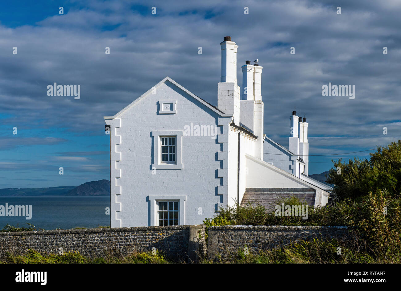 Whitewashed Coastguard Cottages at Trwyn Du Penmon Anglesey off North Wales on a sunny September afternoon. These are now used as holiday homes. Stock Photo