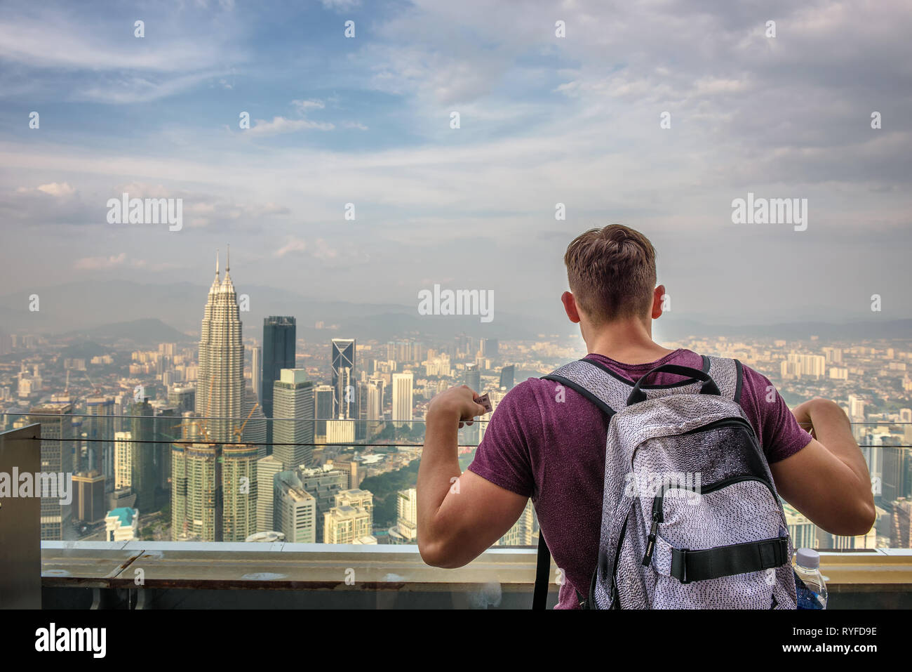 Tourist with a backpack enjoys the panoramic view of the Kuala Lumpur skyline Stock Photo