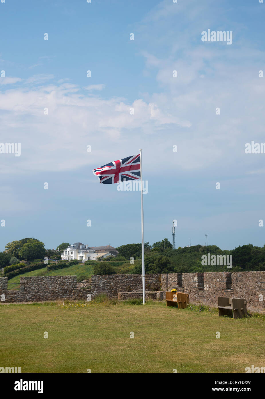 The Union Jack flag flying at full-mast, at Mont Orgueil Castle in Gorey, on the island of Jersey in the English Chanel Stock Photo
