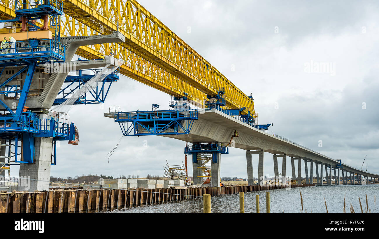 Workes glue together elements of concrete at a construction site of a