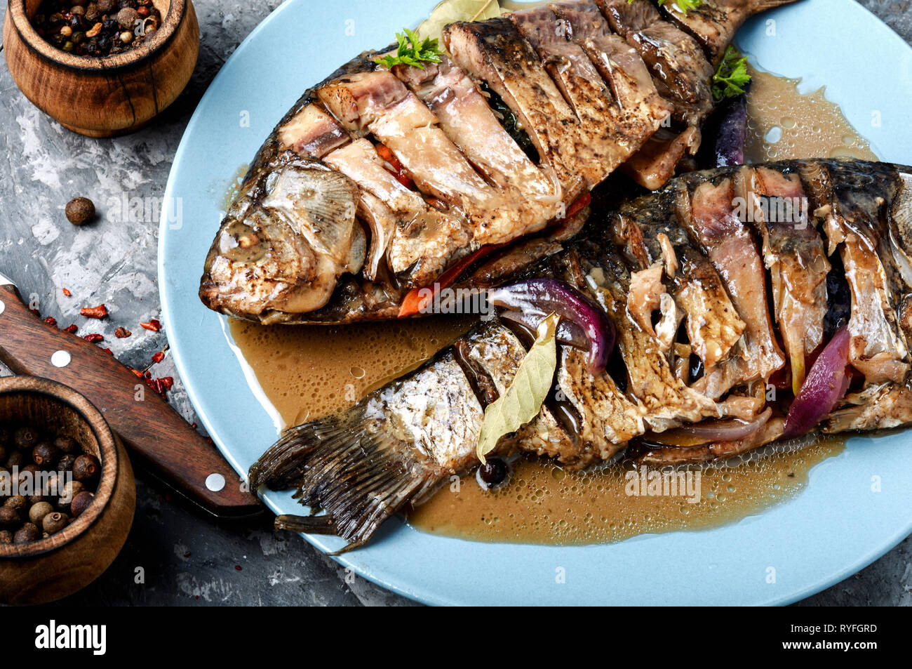 Grilled whole fish loaded with citrus,vegetable and spices on rustic ...