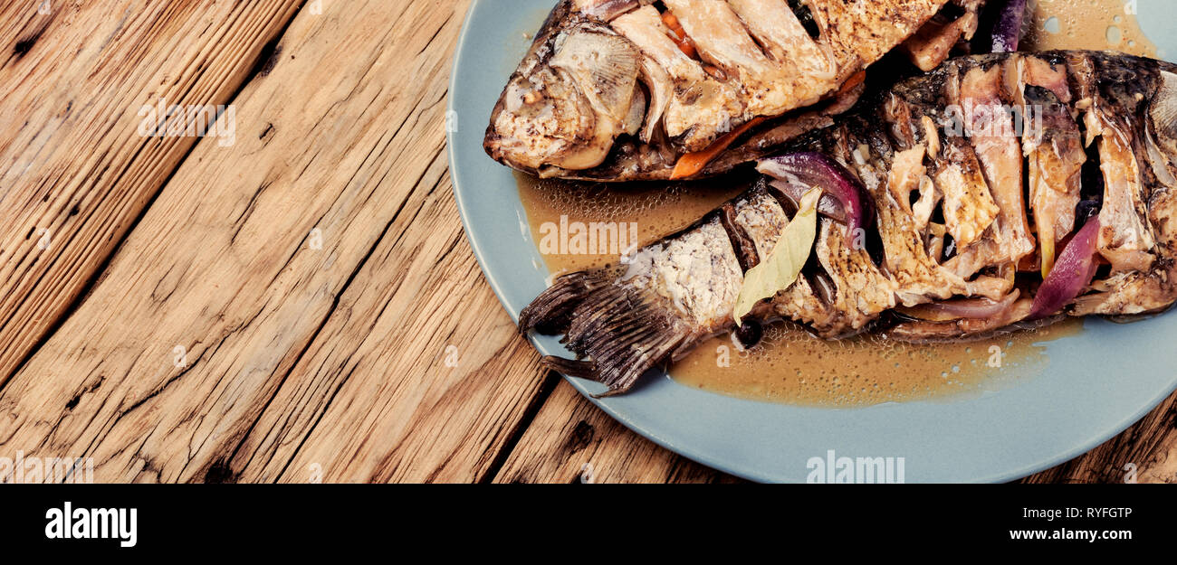 Grilled whole fish loaded with citrus, herbs and spices on rustic ...