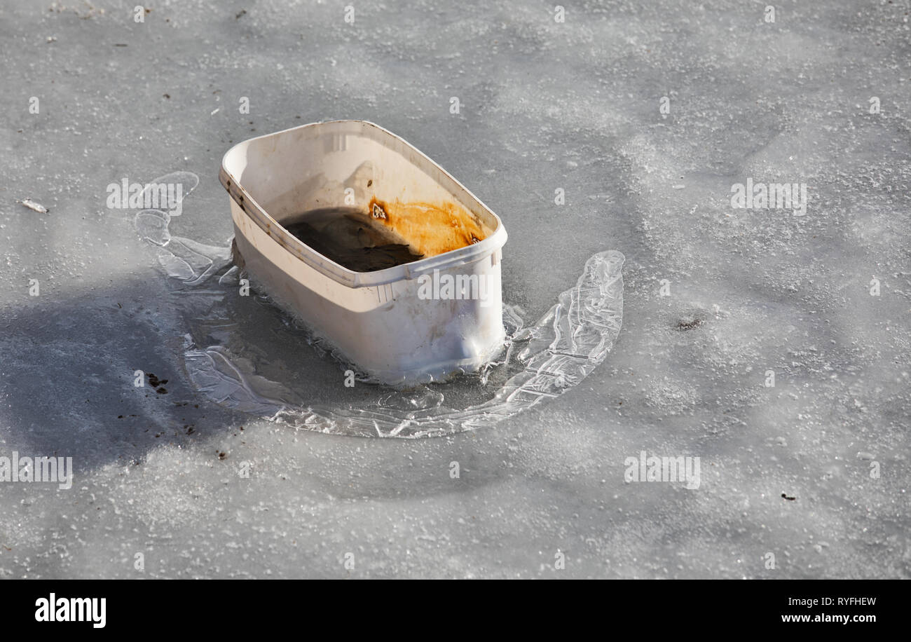 Plastic box discarded and frozen in lake, Sweden, Scandinavia Stock Photo