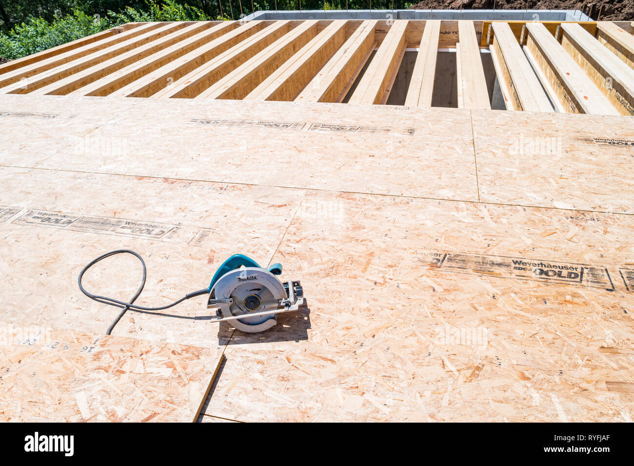 Circular hand saw and underfloor particleboard during house construction Stock Photo