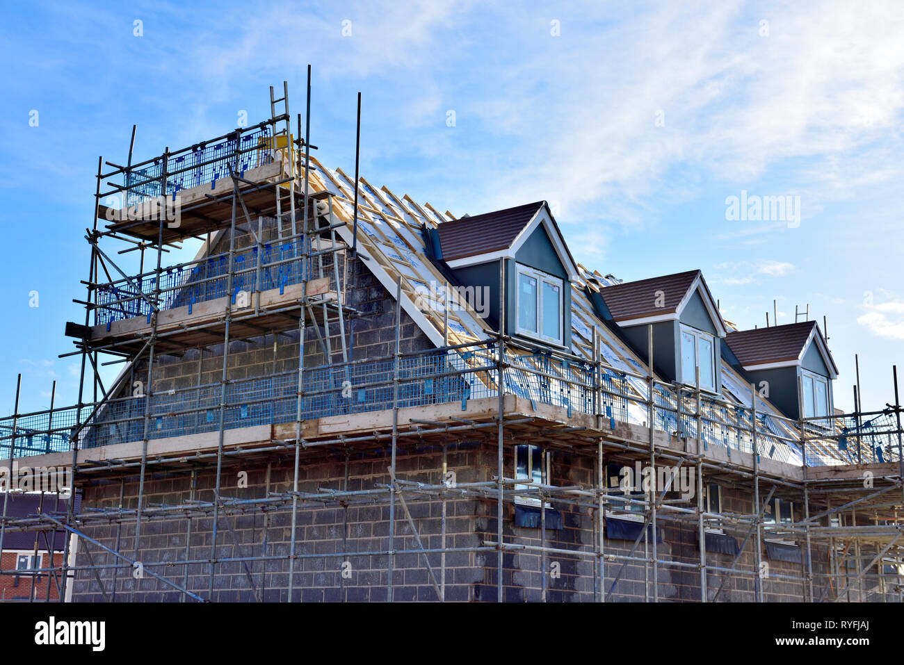 New build construction of apartments with inner skin of concrete blocks and dormer windows, England Stock Photo