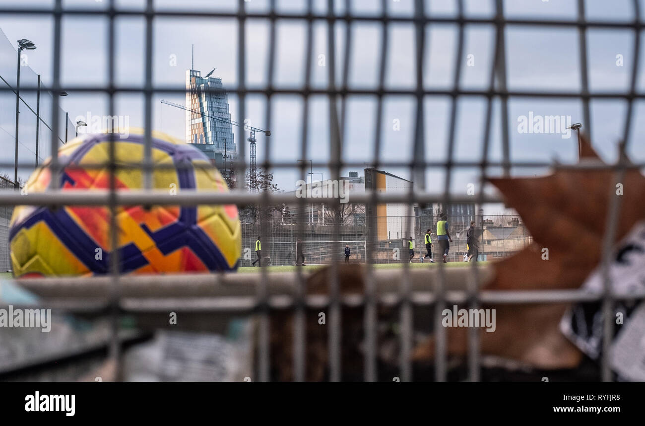 Football being played in inner city urban space above a car perk Stock Photo