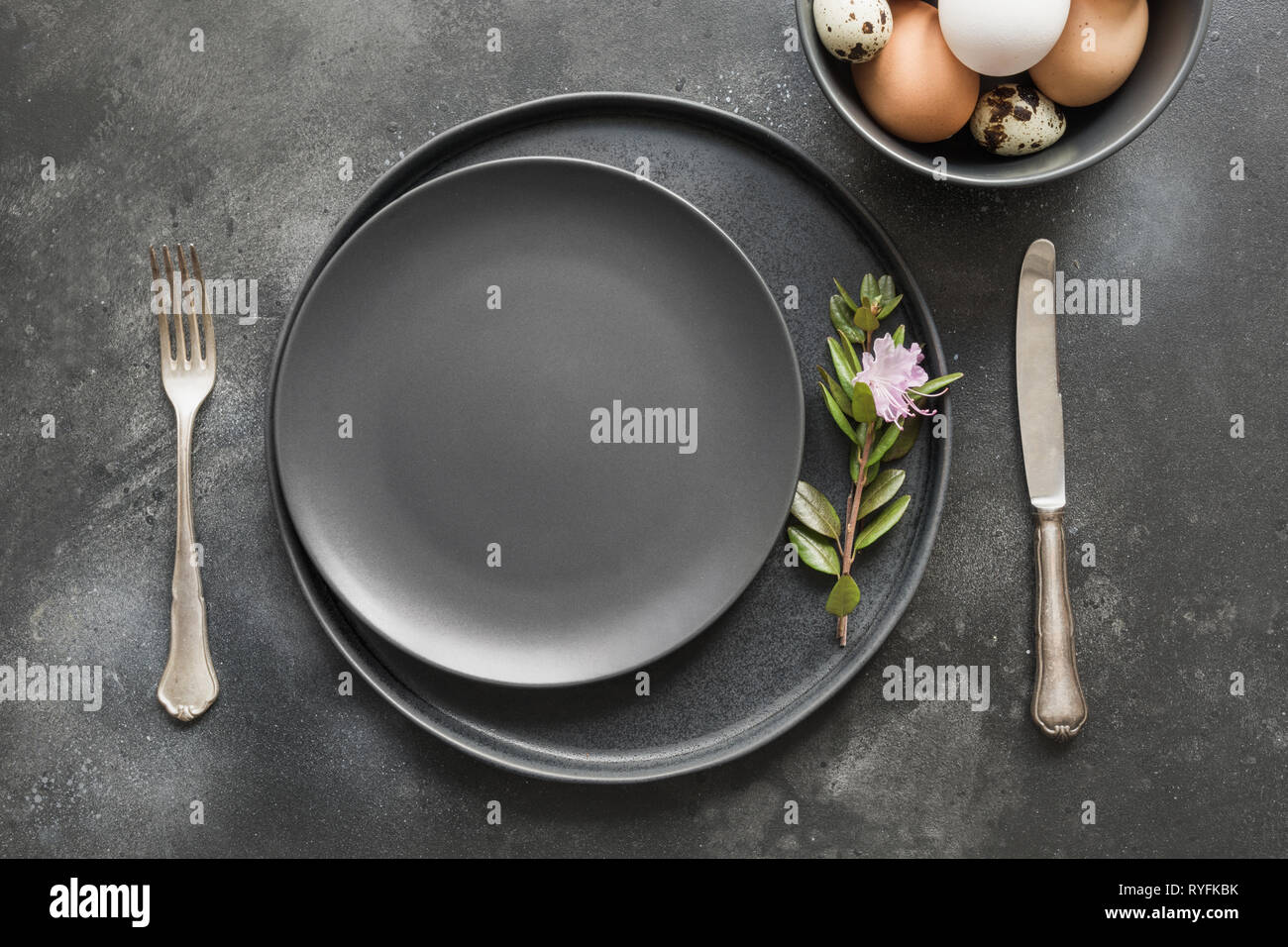 Elegance easter table setting with spring pink flowers on dark. Easter romantic dinner. Top view. Stock Photo