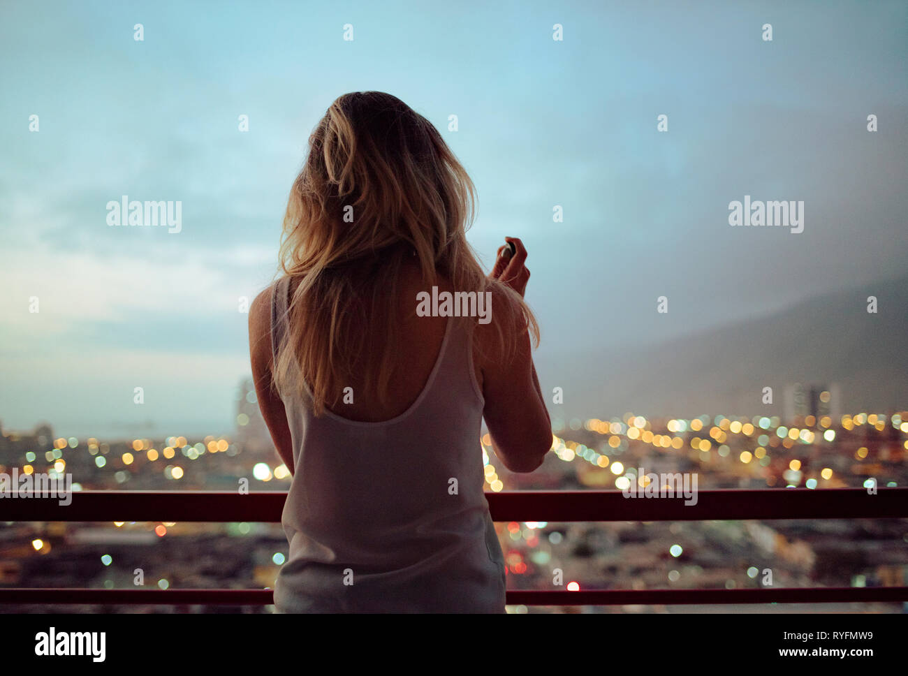 Rear view of disheveled woman looking at view. Switching off / shutting off after a hard day. Lifestyle / city life / mindfulness concept. May 2018 Stock Photo