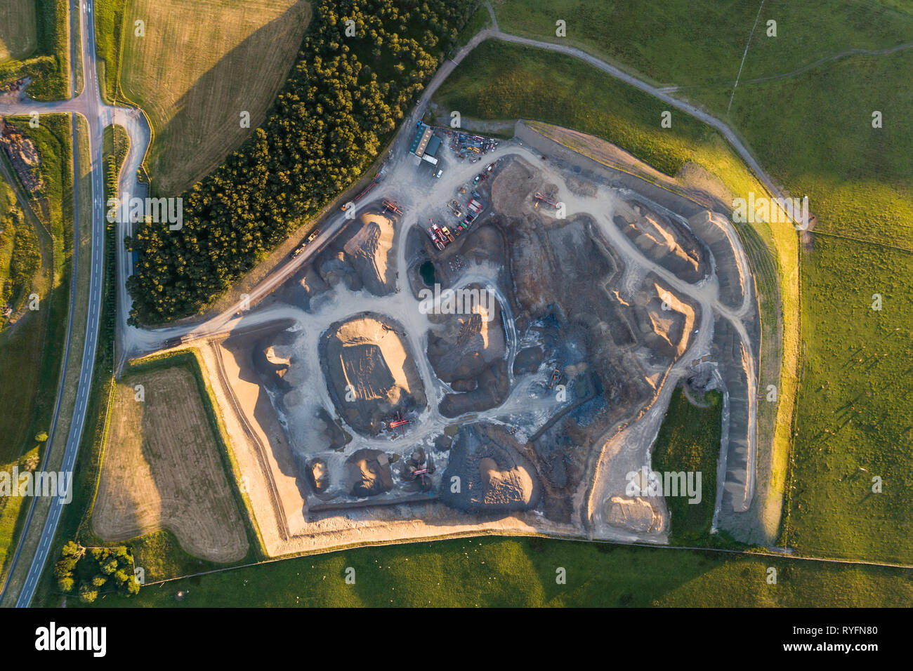 A small aggregate quarry in South Lanarkshire photographed from above in evening light showing crushers, grading machines and piles of aggregate. Stock Photo