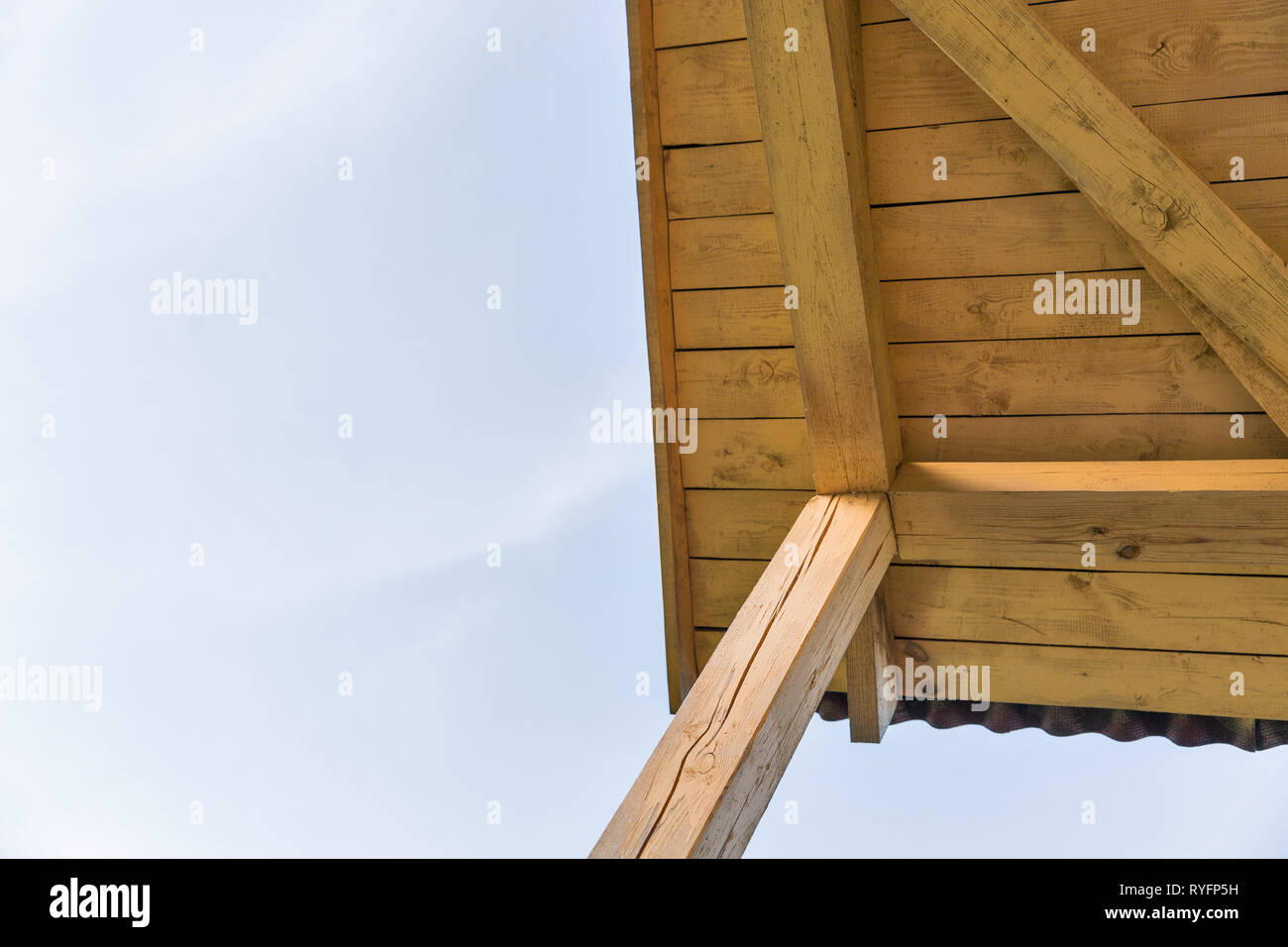 view of the construction of a pitched roof and clear blue sky with copy space Stock Photo