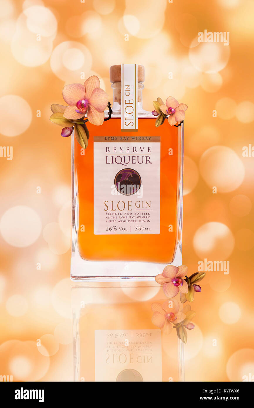 Bottle of Lyme Bay Winery Reserve Liqueur Sloe Gin on a floral background Stock Photo