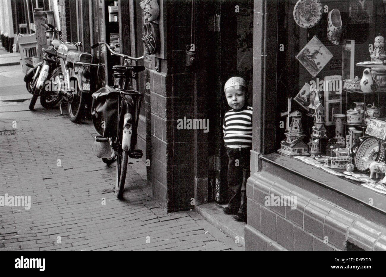 Boy in a shop door, Amsterdam, Netherlands Stock Photo