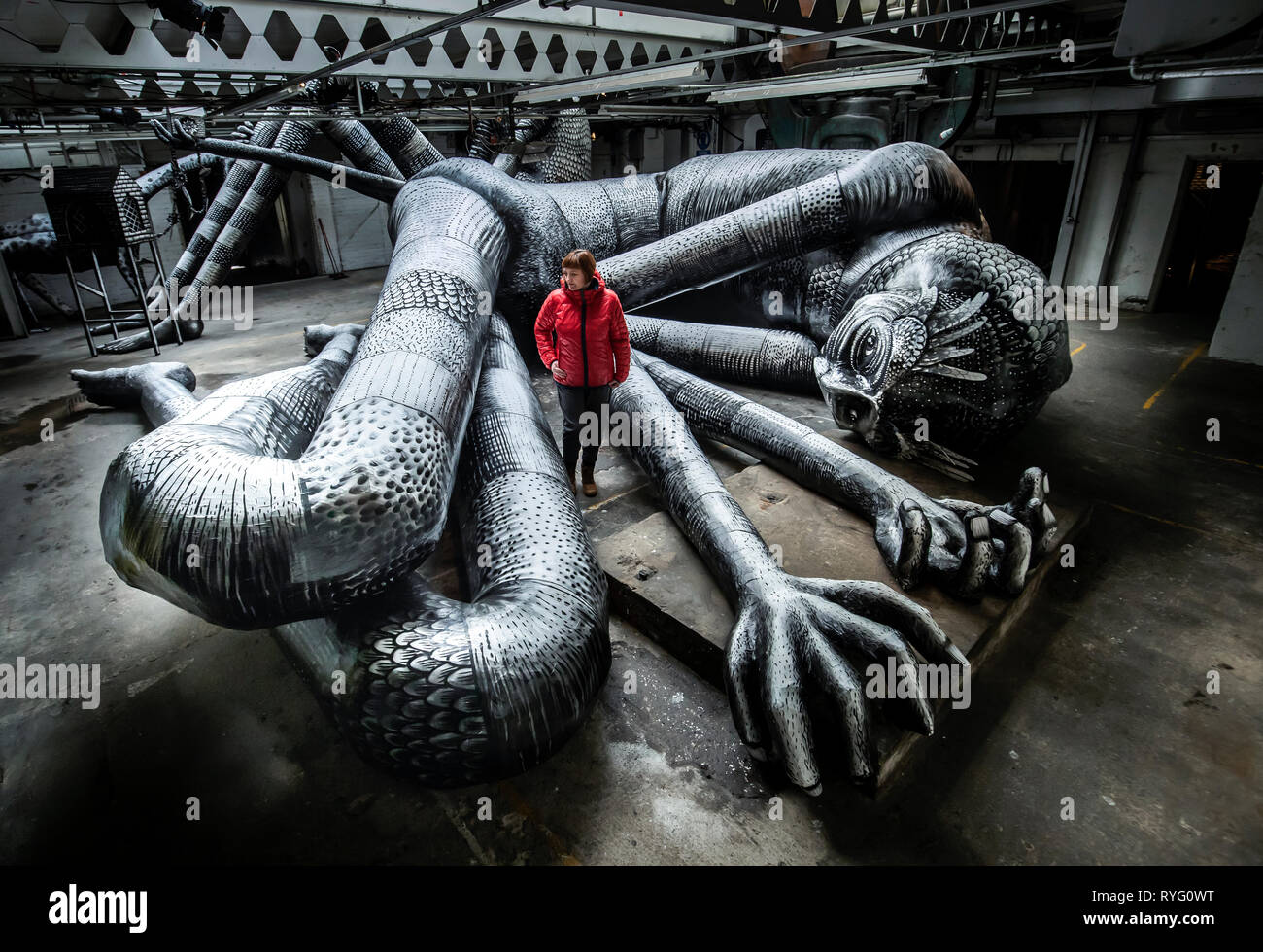 Producer Tamar Millen views one of the artworks on display during the Mausoleum of the Giants, a solo show created by artist Phlegm at the Eyewitness Works in Sheffield. Stock Photo
