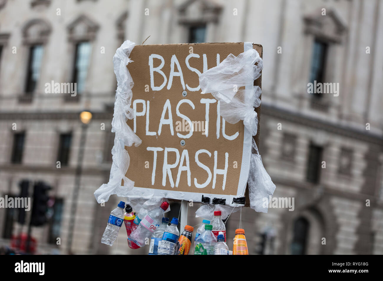 LONDON, UK - March 13 2019: Protestor holds ban plastic trash banner at protest Stock Photo