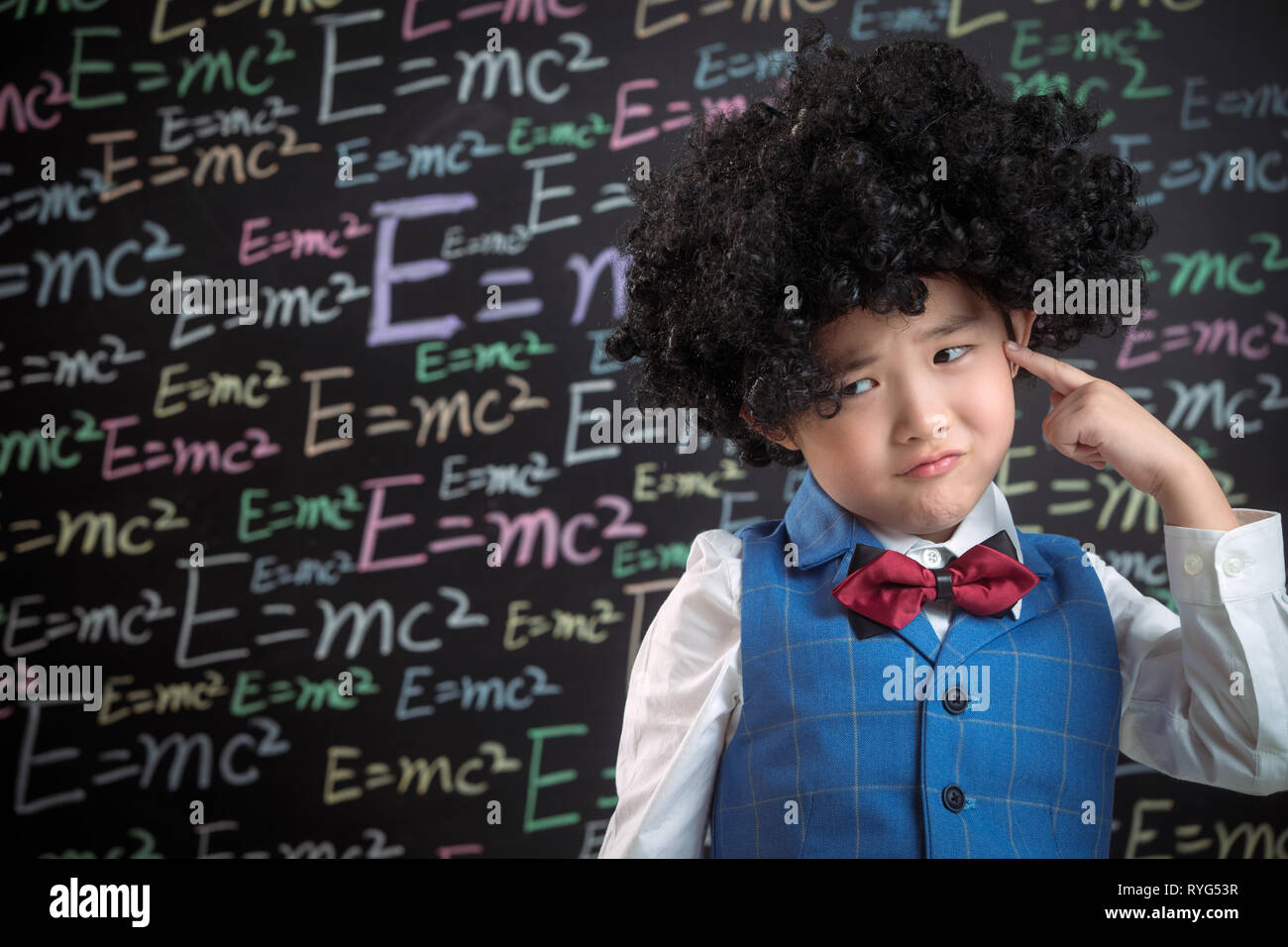 Primary school boy standing in front of the blackboard Stock Photo