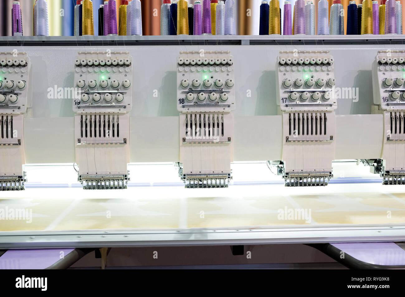 Close-up row of embroidery machine working on factory industry ...
