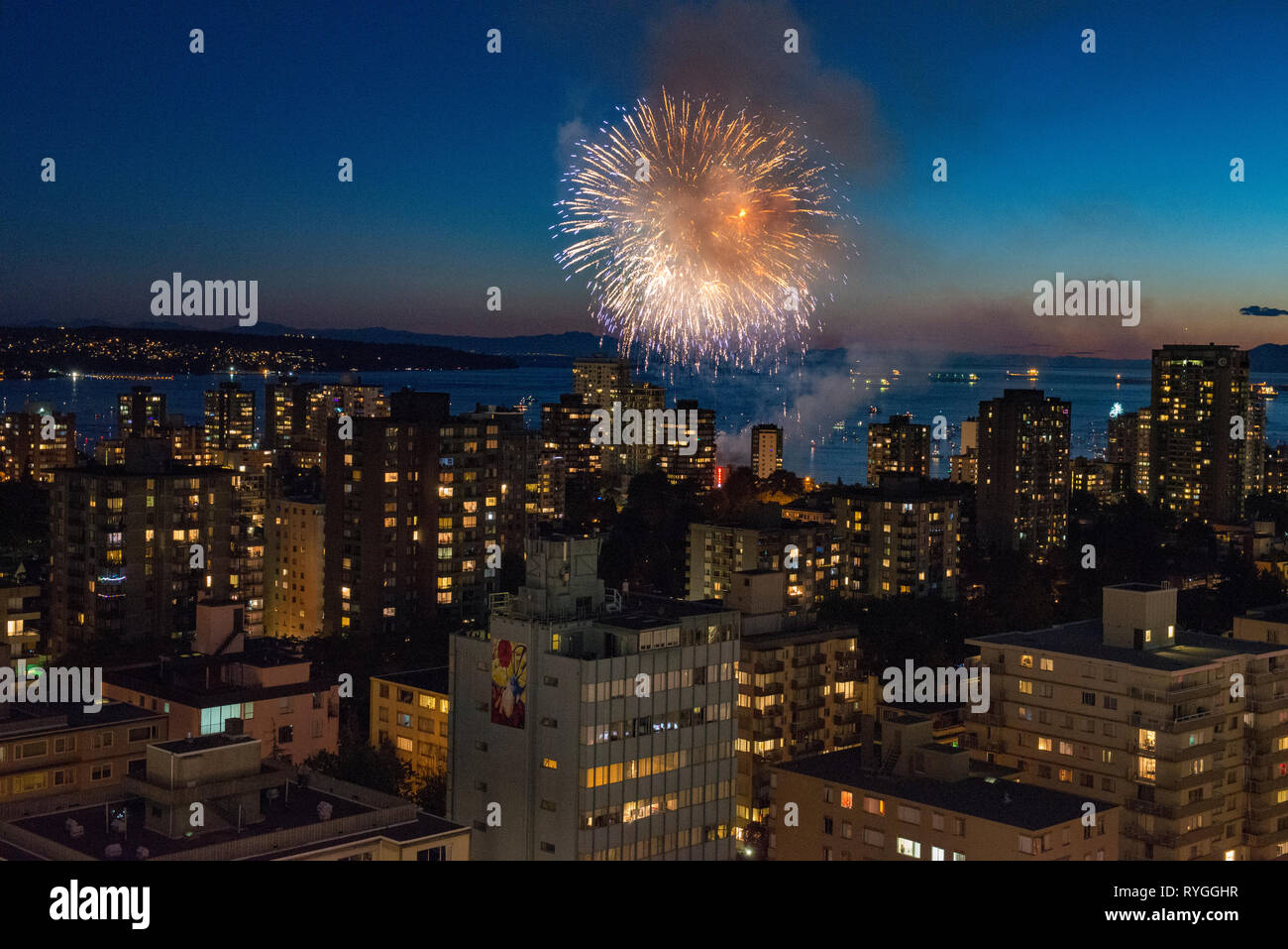 Fireworks bursting across the sky over Vancouver, British Columbia with the city skyline in the foreground. Stock Photo