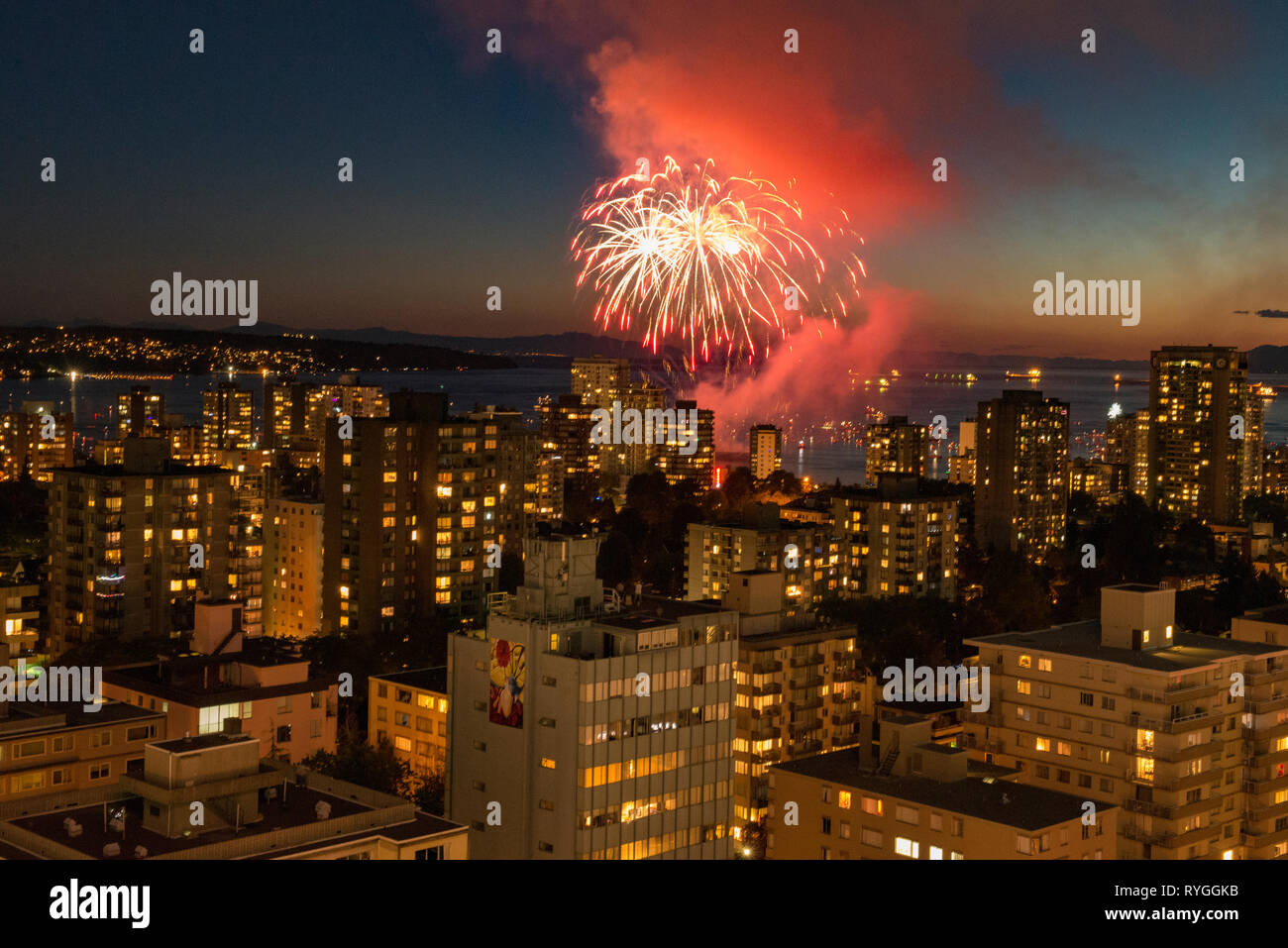 Fireworks bursting across the sky over Vancouver, British Columbia with the city skyline in the foreground. Stock Photo