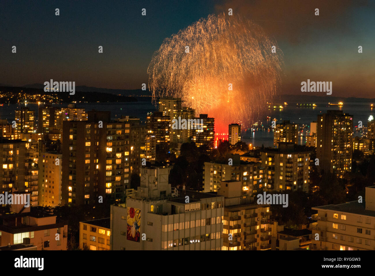 Fireworks bursting across the sky over Vancouver, British Columbia with the city skyline in the foreground. Stock Photo