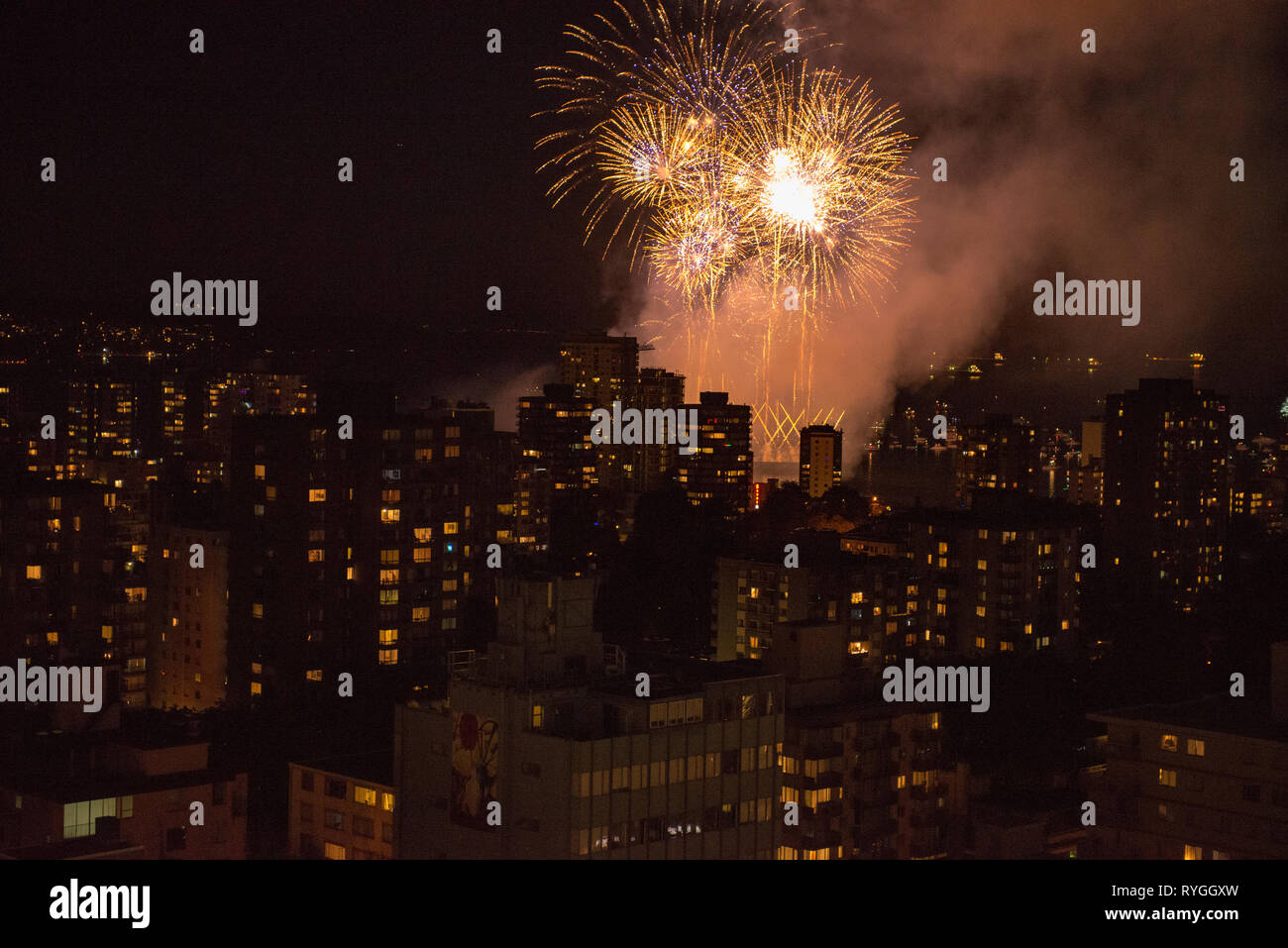 Fireworks bursting across the sky over Vancouver, British Columbia with the city skyline in the foreground. Stock Photo