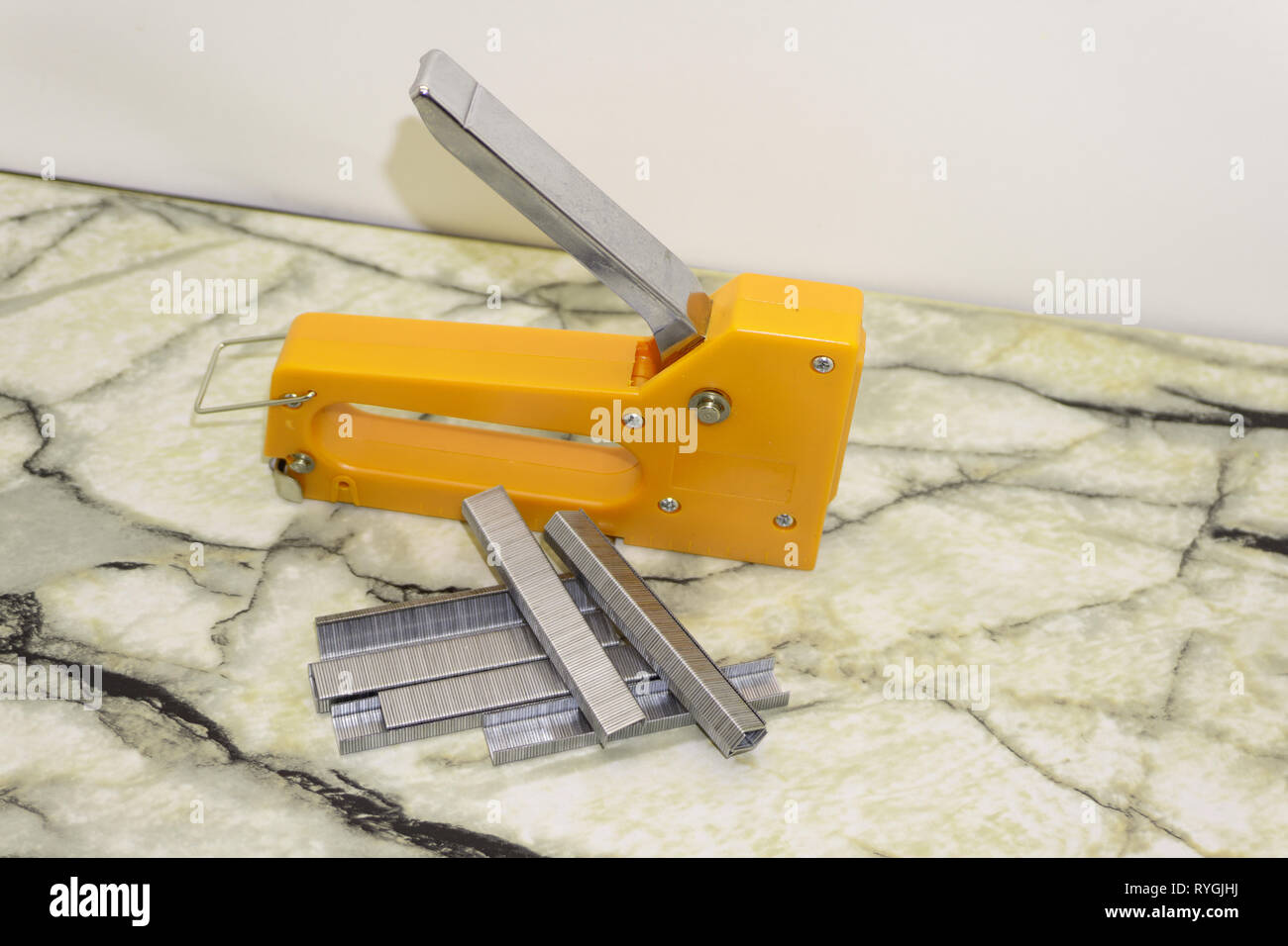Large stapler and staples for construction work on white Stock Photo
