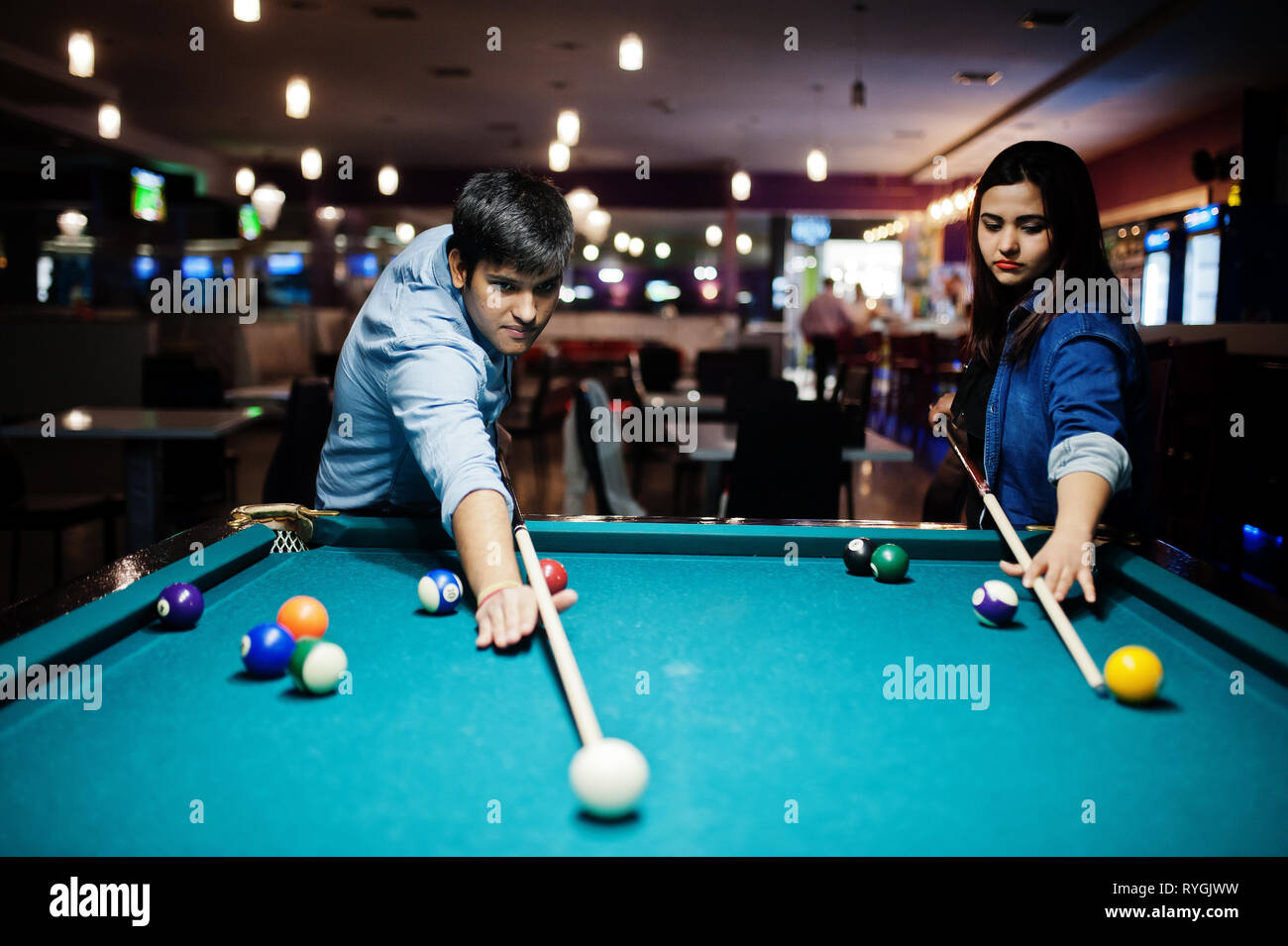 Stylish asian couple wear on jeans playing pool billiard on bar Stock Photo  - Alamy