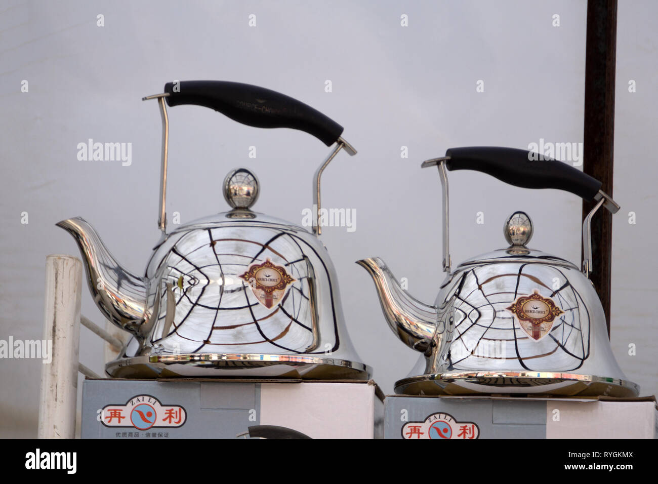 Shiny stainless tea kettle teapot with boiling water on burning gas stove on modern kitchen