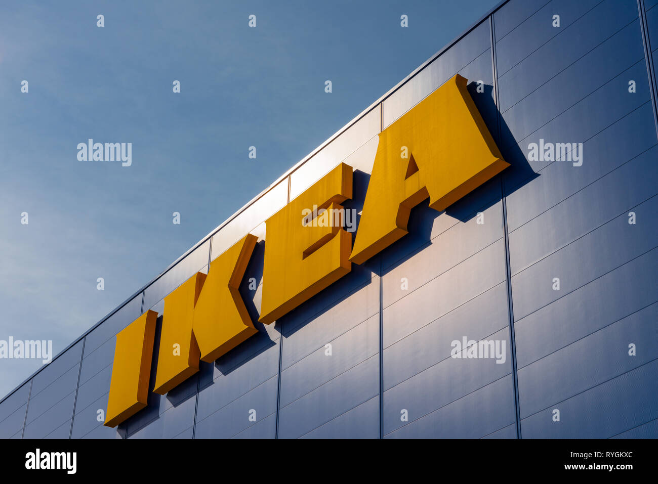 Ikea logo sign against blue sky. Ikea brand yellow and blue colors colours. Yellow logo on blue wall. Opposite colors colours. Stock Photo