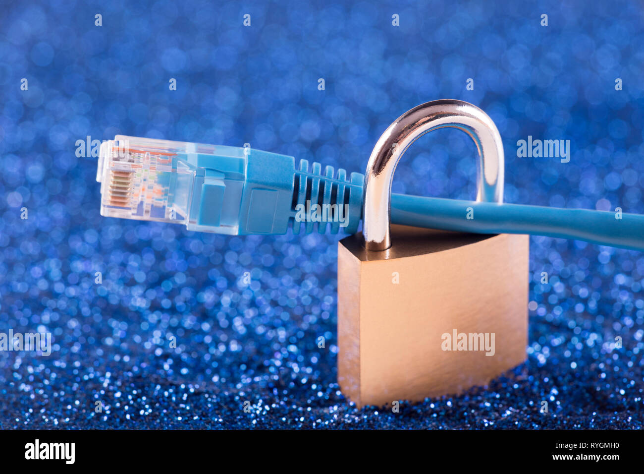 Internet security concept. Padlock with internet cable over blue sparkles background Stock Photo